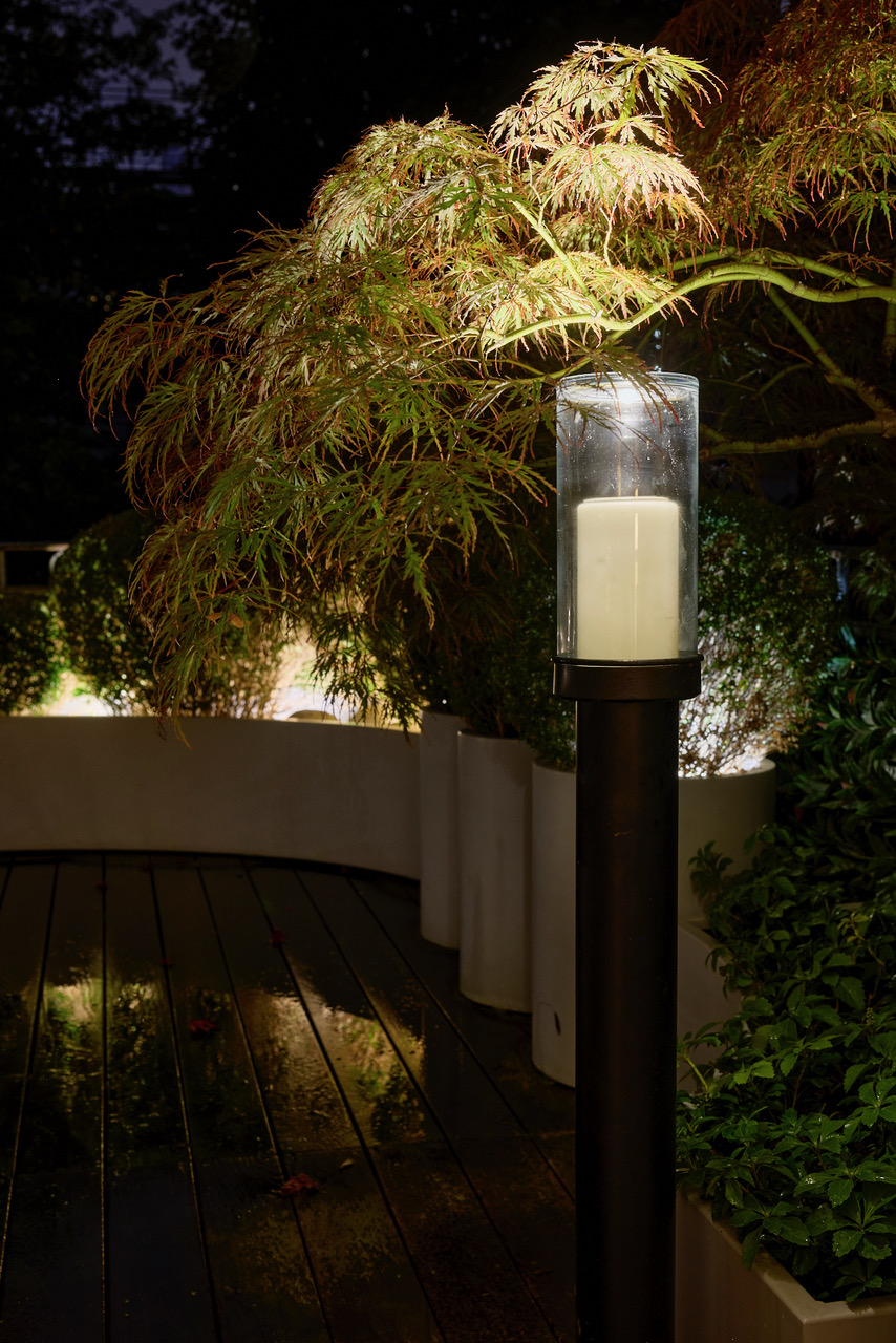 Exterior electric standing candle unit at night